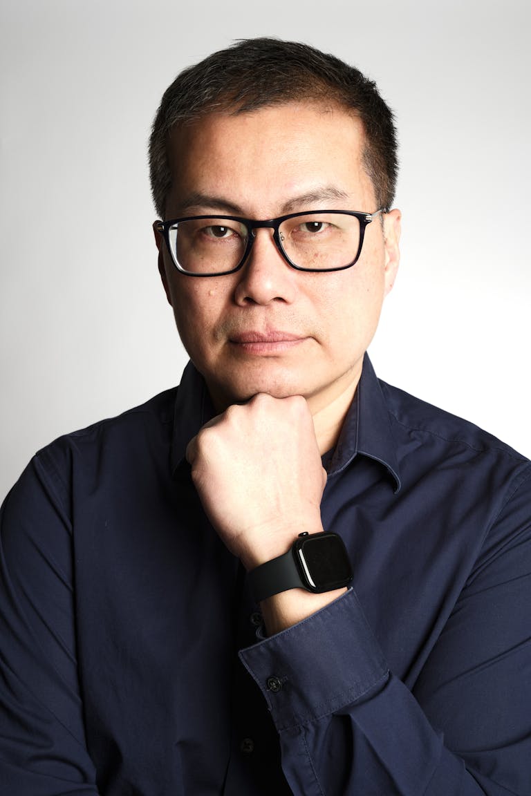 Confident businessman posing in a studio with a thoughtful expression. Perfect for corporate or professional use.