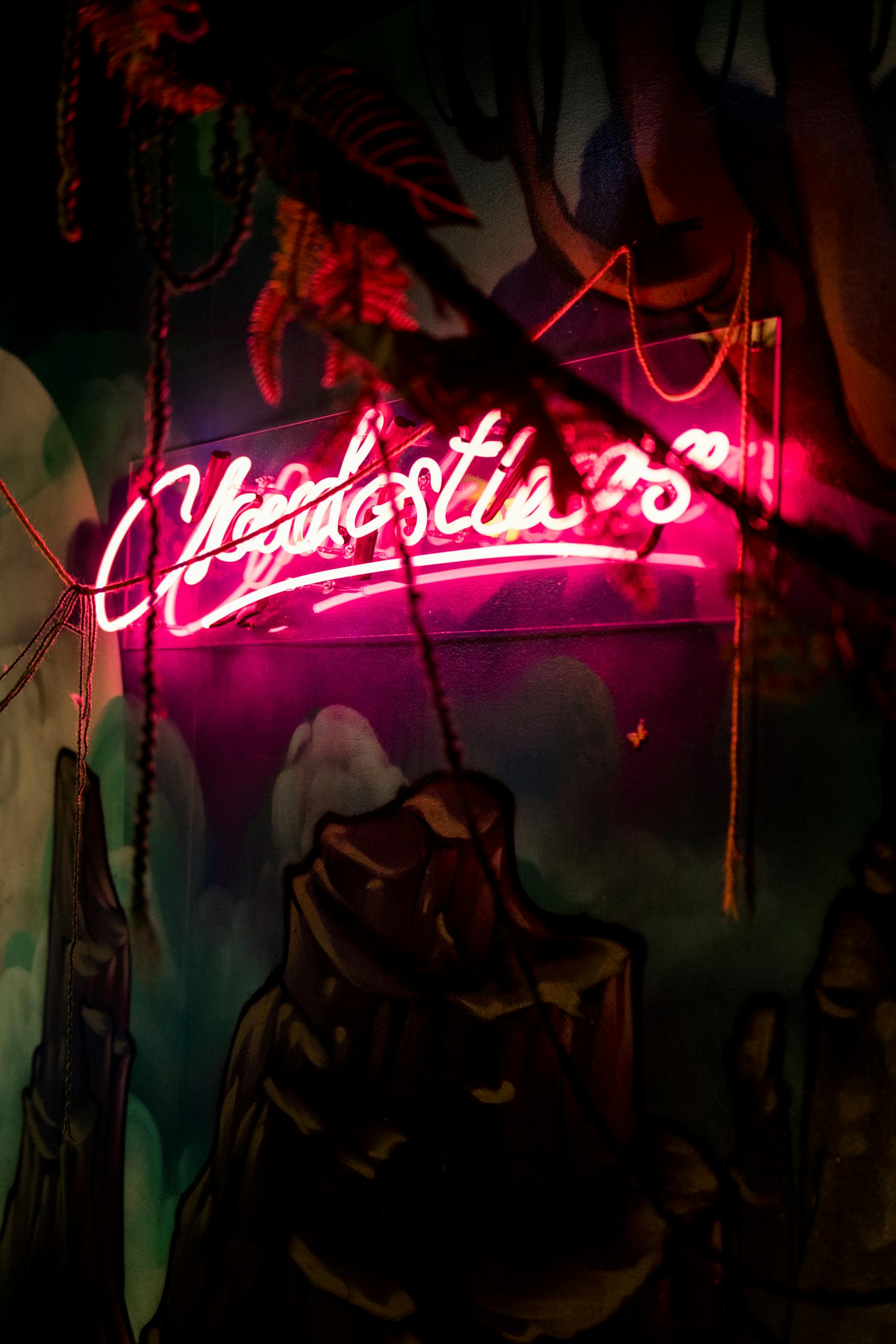 Illuminated neon sign in a jungle-themed setting exudes a vibrant nightlife atmosphere.